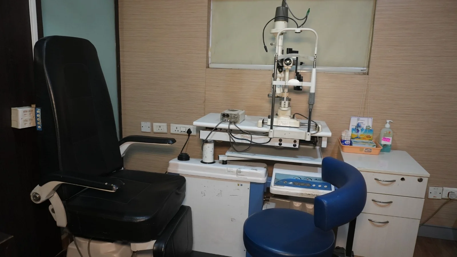 Wide view of a consulting room with slit lamp and examination chair